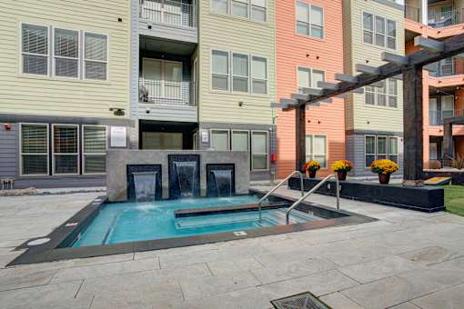 Resident courtyard with grills, putting green and hot tub | Vista at the Heights Apartments in Lansing MI