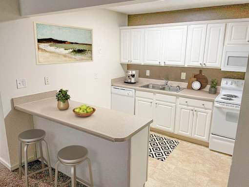a kitchen with white cabinets and a counter with two stools