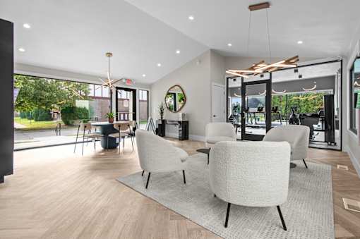 A modern living room with a large window and a view of the outdoors at Park On Canal Apartments - Clinton Twp, MI Apartments, Clinton Twp