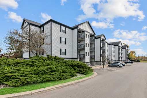 Apartment building with a parking lot in front.