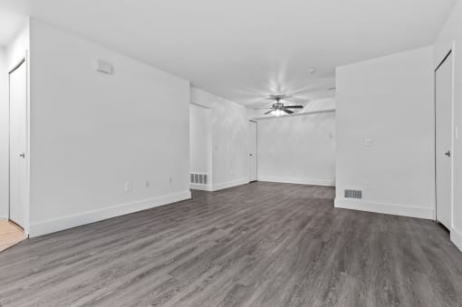 a bedroom with hardwood floors and white walls