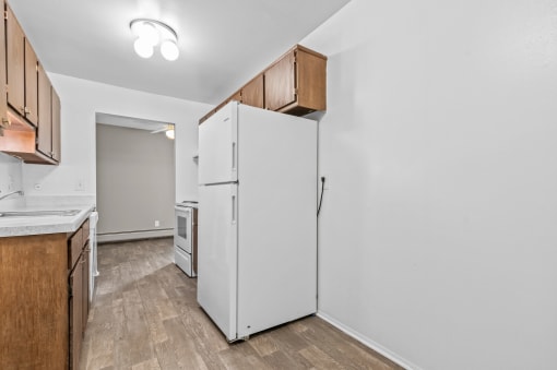 a kitchen with a white refrigerator and wooden cabinets