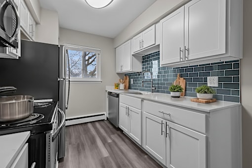 A kitchen with white cabinets and a black stove top.
