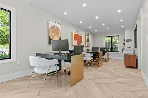 A modern home office with a desk, chairs, and a computer at Park On Canal Apartments - Clinton Twp, MI Apartments, Michigan