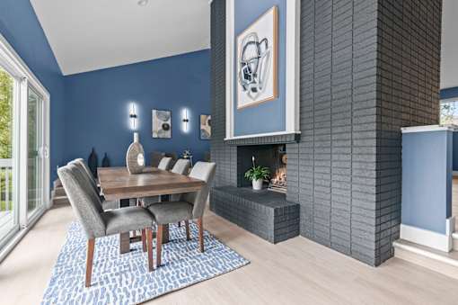 a dining room with blue walls and a wooden table and chairs