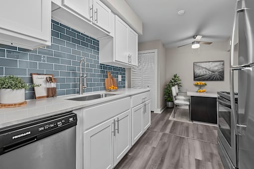 A kitchen with a black dishwasher and a black fridge.