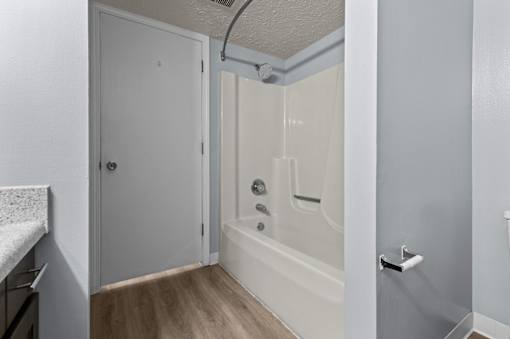 a bathroom with a shower and a sink and a door