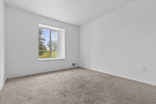 a bedroom with a window and carpet