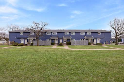 A blue building with a green lawn in front.