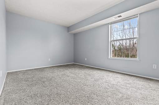 an empty room with carpet and a window