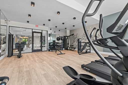 A gym with a variety of equipment including treadmills and weights at Park On Canal Apartments - Clinton Twp, MI Apartments, Clinton Twp, Michigan