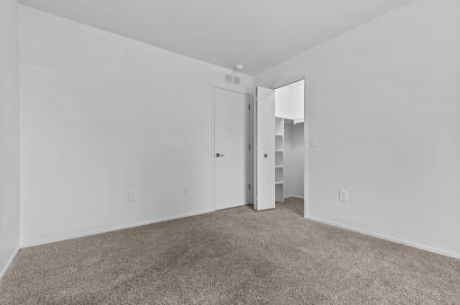 a bedroom with white walls and carpet