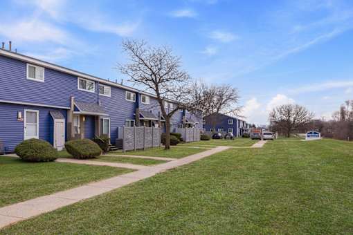 A row of houses with a grassy area in front.