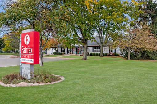 A sign for Fairfax Apartments stands in a grassy area.