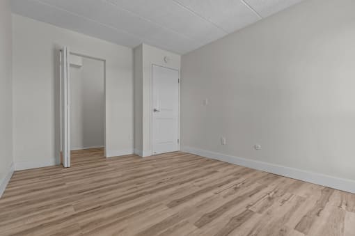 an empty living room with wood flooring and white walls