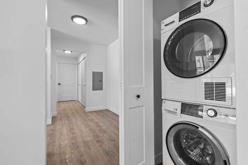 a white washer and dryer in a white laundry room with a white door