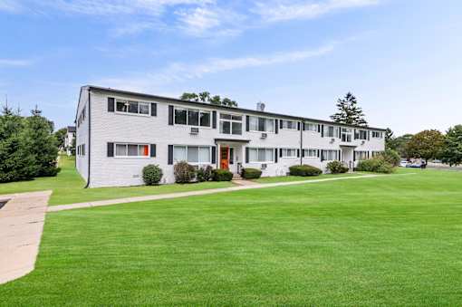 the view of an apartment building with a green lawn