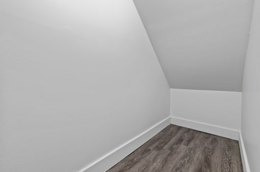 an empty room with a wooden floor and white walls