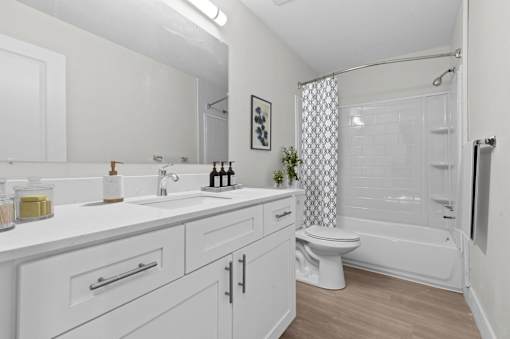 A white bathroom with a toilet, sink, and bathtub.