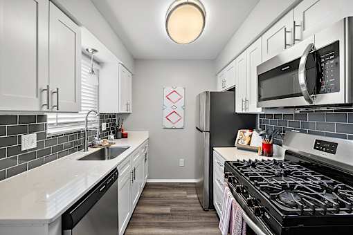 a kitchen with stainless steel appliances and white cabinets