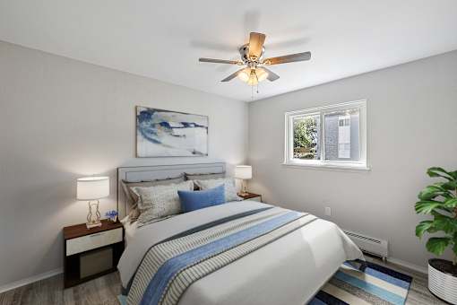 A bedroom with a bed, nightstand, and a ceiling fan.