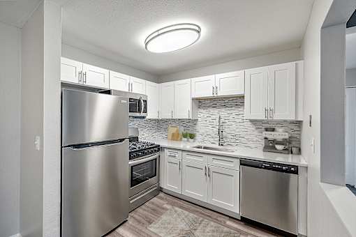 A modern kitchen with stainless steel appliances and white cabinets.