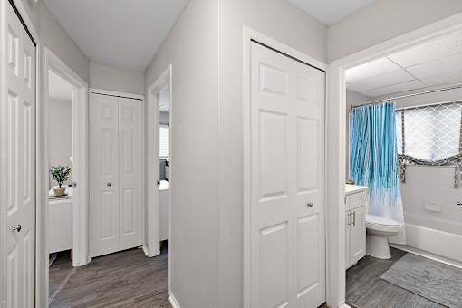 A white bathroom with a blue shower curtain.