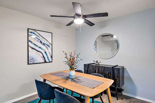 A dining room with a wooden table and chairs.