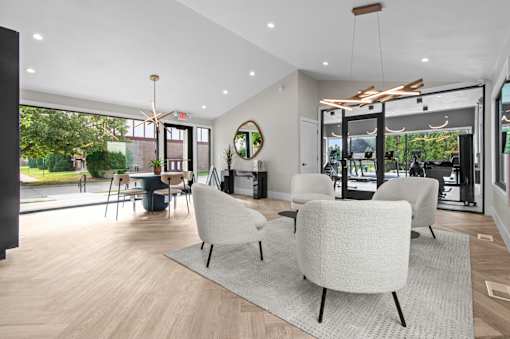 A modern living room with white furniture and a large window at Park On Canal Apartments - Clinton Twp, MI Apartments, Apartments, Clinton Twp, MI