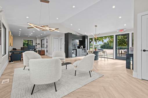 A modern living room with white chairs and a grey rug at Park On Canal Apartments - Clinton Twp, MI Apartments, Clinton Twp, 48038
