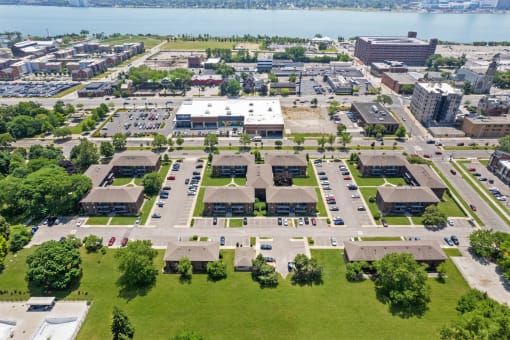 an aerial view of a parking lot with buildings in the background and a body of water in at Lafayette Park Place, Detroit, MI, Detroit, Michigan
