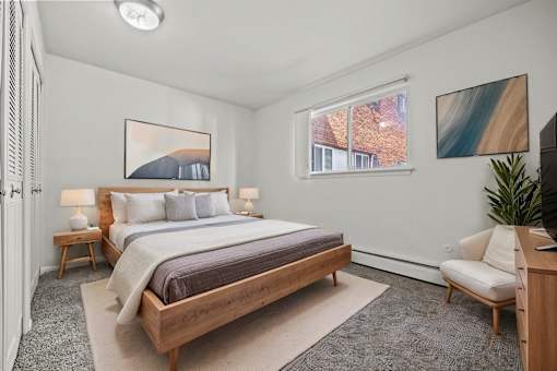 A bedroom with a large bed and a painting on the wall.