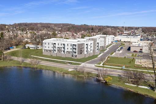 A large white building sits next to a body of water.