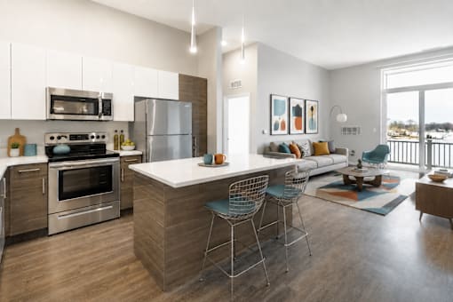 A modern kitchen with a large island and a view of the outdoors.