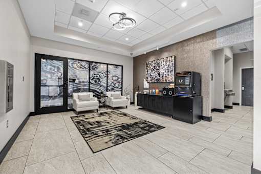 A modern living room with a black entertainment center and a large abstract painting on the wall.