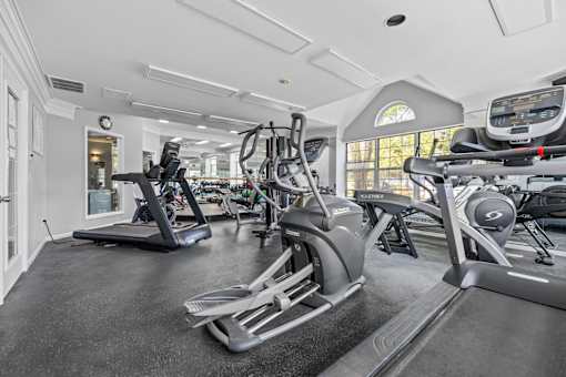 A spacious gym with treadmills, elliptical machines, and other exercise equipment.