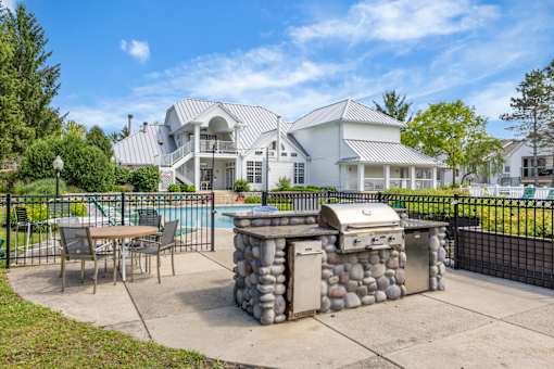 A backyard with a stone BBQ and a pool table.