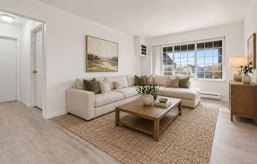 A living room with a white couch, a brown coffee table, and a painting on the wall.