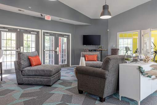 A living room with grey chairs, a white cabinet, and a flat screen TV.