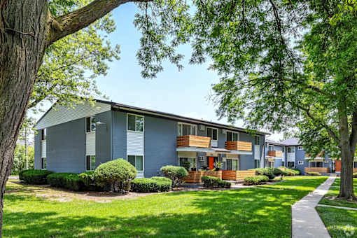 A modern house with a blue exterior and a well-maintained lawn.