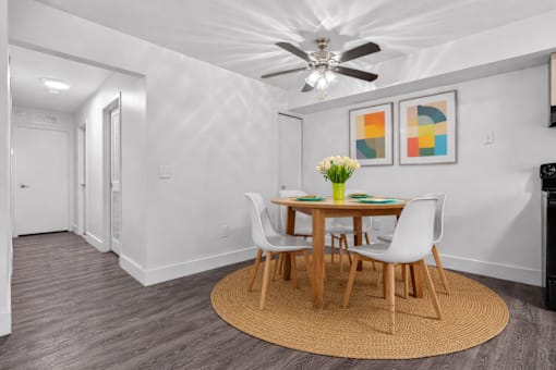 A dining room with a round table and chairs.