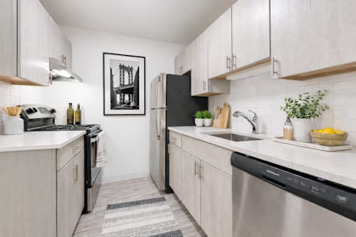 A kitchen with white cabinets and a black fridge.