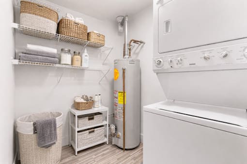 A laundry room with a washer and dryer, a basket, and a towel.