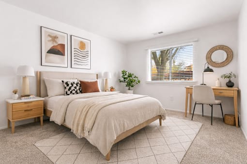 A bedroom with a large bed, a desk, and a chair.