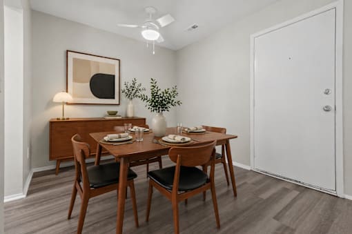 A dining room with a wooden table set for two.