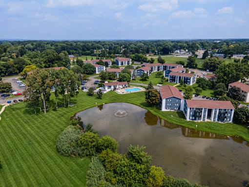 A flooded area in front of a building surrounded by trees.