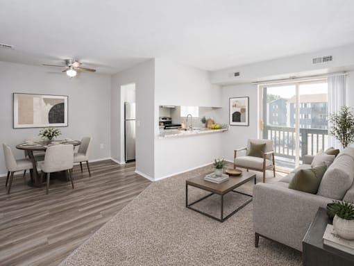 A living room with a grey couch, a coffee table, and a dining table with chairs.
