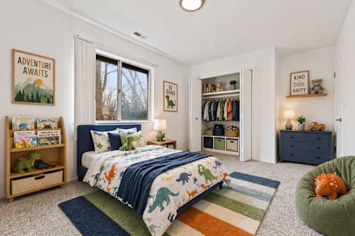 A bedroom with a bed, a chair, and a bookshelf.