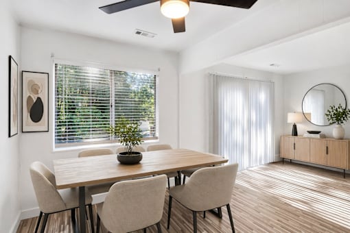 A dining room with a wooden table and chairs.