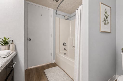 A bathroom with a white tub and a white door.
